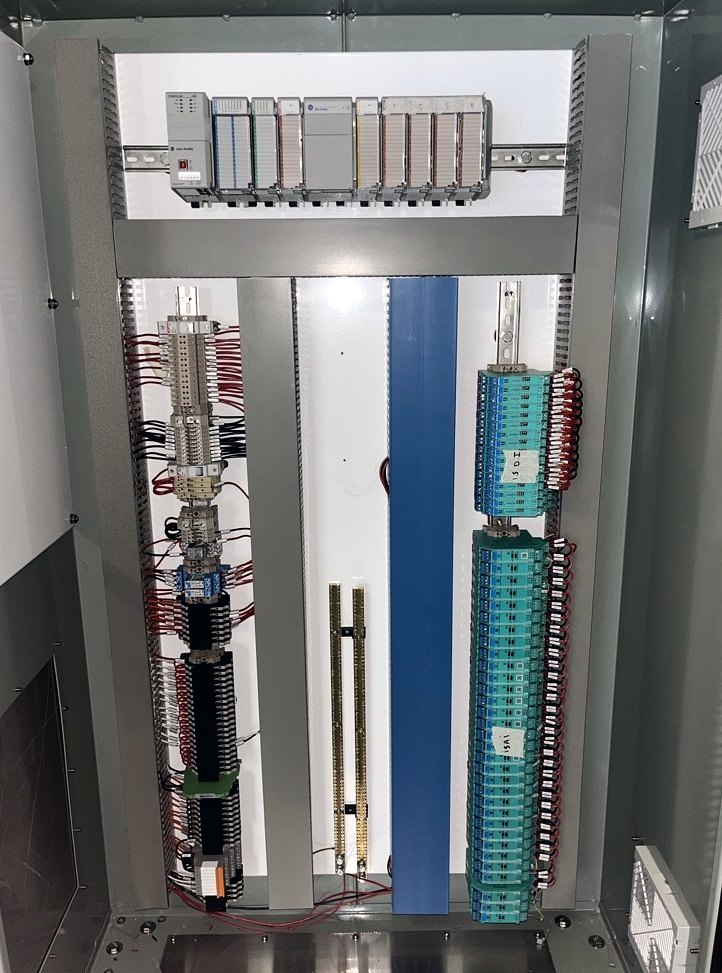 Internals of the new control panel showing the PLC rack and terminal rows
